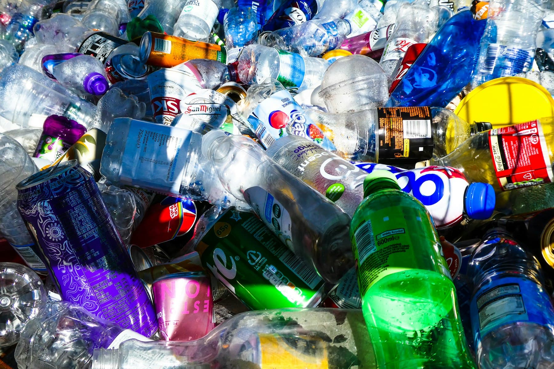 A large pile of collected plastic bottles and aluminum cans sorted for recycling